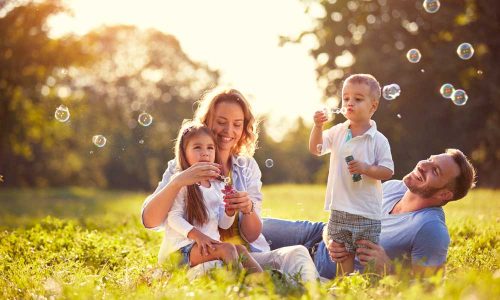 Family-with-children-blow-soap-bubbles-outdoor